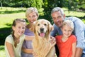Happy family smiling at the camera with their dog Royalty Free Stock Photo