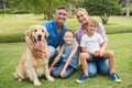 Happy family smiling at the camera with their dog Royalty Free Stock Photo