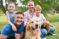 Happy family smiling at the camera with their dog Royalty Free Stock Photo