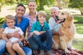 Happy family smiling at the camera with their dog Royalty Free Stock Photo