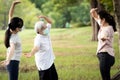 Happy family smiling while exercising at outdoor park,mother,daughter and healthy grandmother are stretching arm workout,wearing Royalty Free Stock Photo