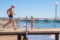 Happy family. Smiling grandfather and grandson playing at the sea. Running to the wave. Positive human emotions, feelings,