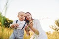 Happy family smiling and having fun. Young mother with her little son is outdoors in the agricultural field. Beautiful sunshine Royalty Free Stock Photo