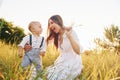 Happy family smiling and having fun. Young mother with her little son is outdoors in the agricultural field. Beautiful sunshine Royalty Free Stock Photo