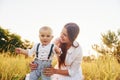 Happy family smiling and having fun. Young mother with her little son is outdoors in the agricultural field. Beautiful sunshine Royalty Free Stock Photo