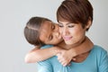 Happy family with smiling, positive daughter kissing her mother'