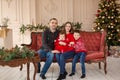 Happy family on sofa near Christmas tree. Cozy family atmosphere. Enjoyng love hugs, holidays people. Togetherness concept Royalty Free Stock Photo