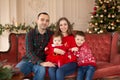 Happy family on sofa near Christmas tree. Cozy family atmosphere. Enjoyng love hugs, holidays people. Togetherness concept Royalty Free Stock Photo