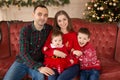 Happy family on sofa near Christmas tree. Cozy family atmosphere. Enjoyng love hugs, holidays people. Togetherness concept Royalty Free Stock Photo