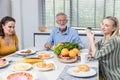 Happy family spend time having lunch or dinner on table together. Senior man enjoying while communicating with their family in din Royalty Free Stock Photo