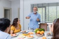 Happy family spend time having lunch or dinner on table together. Senior man enjoying while communicating with their family in din Royalty Free Stock Photo