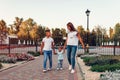 Happy family spending time outdoors walking in park. Mother and her son holding little toddler girl. Family values Royalty Free Stock Photo