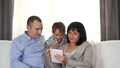 A happy family spends time together watching a movie or playing on a tablet. Concept of family entertainment, education