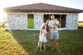 Happy family stand near their new home, construction, dream project, joint construction of a house Royalty Free Stock Photo