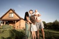 Happy family stand near their new home, joint construction of a house Royalty Free Stock Photo