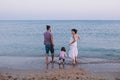 Happy family standing on the beach and looking at sea Royalty Free Stock Photo