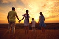 A happy family is standing in the nature at sunset in the evenin