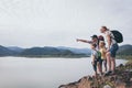 Happy family standing near the lake at the day time Royalty Free Stock Photo