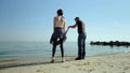 A happy family stands in front of the sea. Parents on the sea shore dandle their child. Slow motion