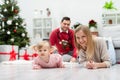 The happy family stays in a room near a decorated Christmas tree and presents Royalty Free Stock Photo