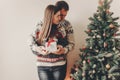 happy family in stylish sweaters exchanging gifts in festive room with christmas tree and lights. emotional moments. merry christ Royalty Free Stock Photo