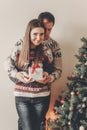 happy family in stylish sweaters exchanging gifts in festive room with christmas tree and lights. emotional moments. merry christ Royalty Free Stock Photo