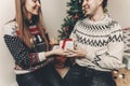 happy family in stylish sweaters exchanging gifts in festive room with christmas tree and lights. emotional moments. merry christ Royalty Free Stock Photo