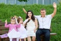 Happy family in summer city park outdoor, pregnant woman, parent and children, bright sunny day and green grass, beautiful people Royalty Free Stock Photo