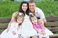 Happy family in summer city park outdoor, pregnant woman, parent and children, bright sunny day and green grass, beautiful people Royalty Free Stock Photo