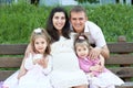 Happy family in summer city park outdoor, pregnant woman, parent and children, bright sunny day and green grass, beautiful people Royalty Free Stock Photo