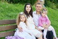 Happy family in summer city park outdoor, pregnant woman, parent and children, bright sunny day and green grass, beautiful people Royalty Free Stock Photo