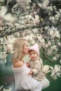 Happy family on a summer meadow. little girl child baby daughter hugging and kissing mother Royalty Free Stock Photo