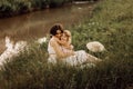 Happy family on a summer meadow. little girl child baby daughter hugging and kissing mother. Family sitting near the Royalty Free Stock Photo