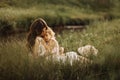 Happy family on a summer meadow. little girl child baby daughter hugging and kissing mother. Family sitting near the Royalty Free Stock Photo