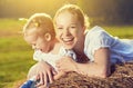 Happy family in summer nature. Mother and baby daughter in the hay, straw Royalty Free Stock Photo
