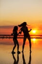 Happy family summer travel holiday. Silhouette of active mom with teen child daughter having fun dancing together on Royalty Free Stock Photo