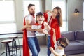 Happy family in superhero costumes playing together. Royalty Free Stock Photo
