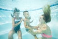 Happy family swimming underwater. Mother, son and daughter having having fun in pool. Royalty Free Stock Photo