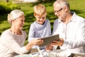 Happy family with tablet pc outdoors Royalty Free Stock Photo