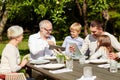 Happy family with tablet pc at table in garden Royalty Free Stock Photo