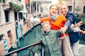 Happy family take a self photo on the one of bridges in Venice