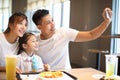 Happy family taking selfie in restaurant. Royalty Free Stock Photo