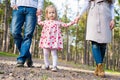 Happy family taking a walk in a park, family holding hands walking together along forrest path Royalty Free Stock Photo