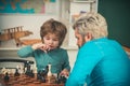 Happy family. Teacher and schoolboy playing chess in class. Child early development.