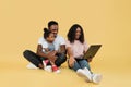 Young african parents sitting on floor with their daughter and embracing using laptop for video call Royalty Free Stock Photo