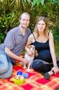 Happy family with their dog and pregnant motherin park Royalty Free Stock Photo