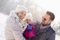 Happy family and their little daughter enjoying a beautiful and cold winter day