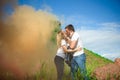 Happy family of three on a background of colored smoke in summer Royalty Free Stock Photo