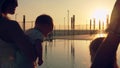 Happy family with three children admiring the sunset reflected in the surface of the pool Royalty Free Stock Photo