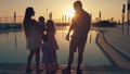 Happy family with three children admiring the sunset reflected in the surface of the pool Royalty Free Stock Photo